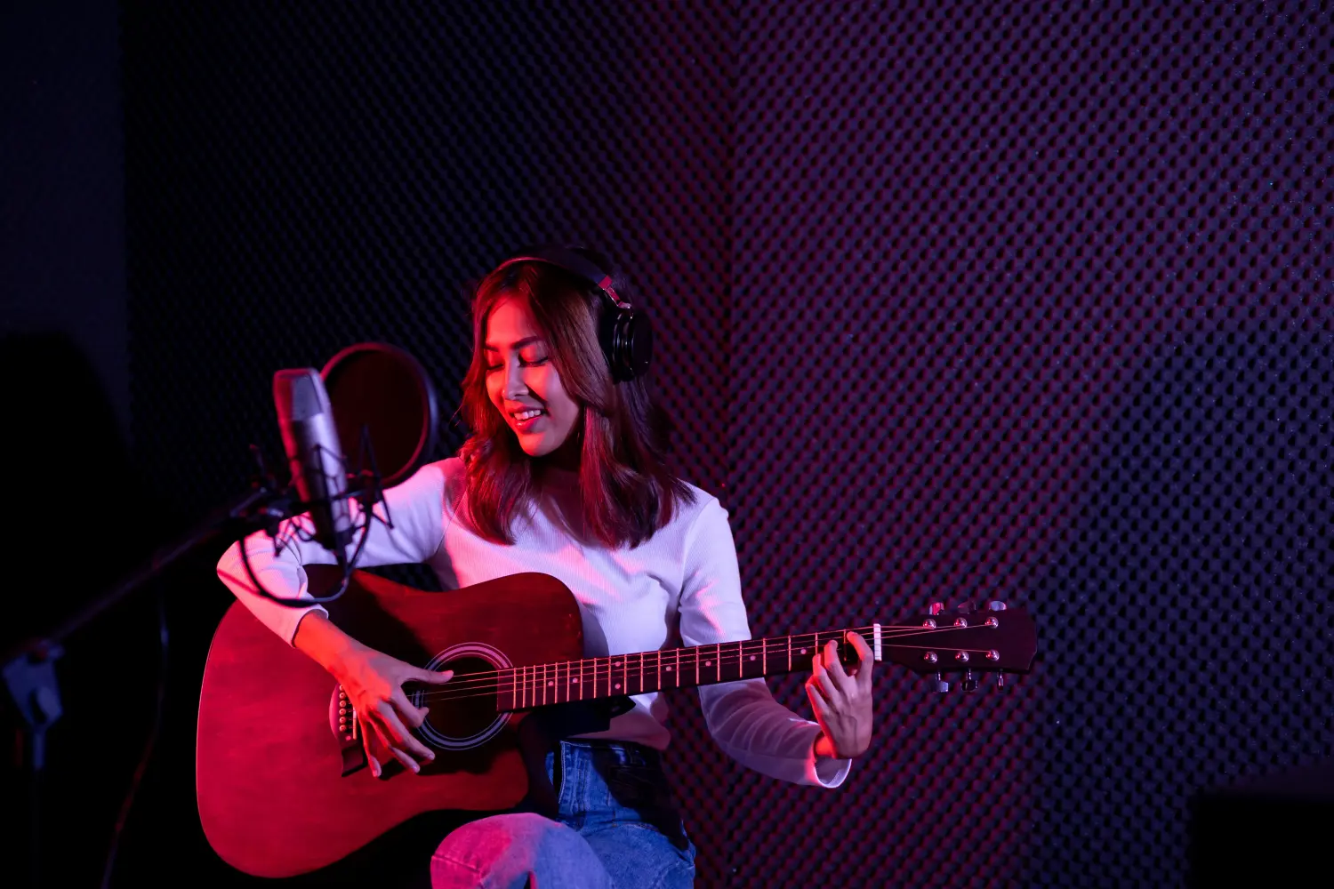 Frau mit Gitarre im Tonstudio